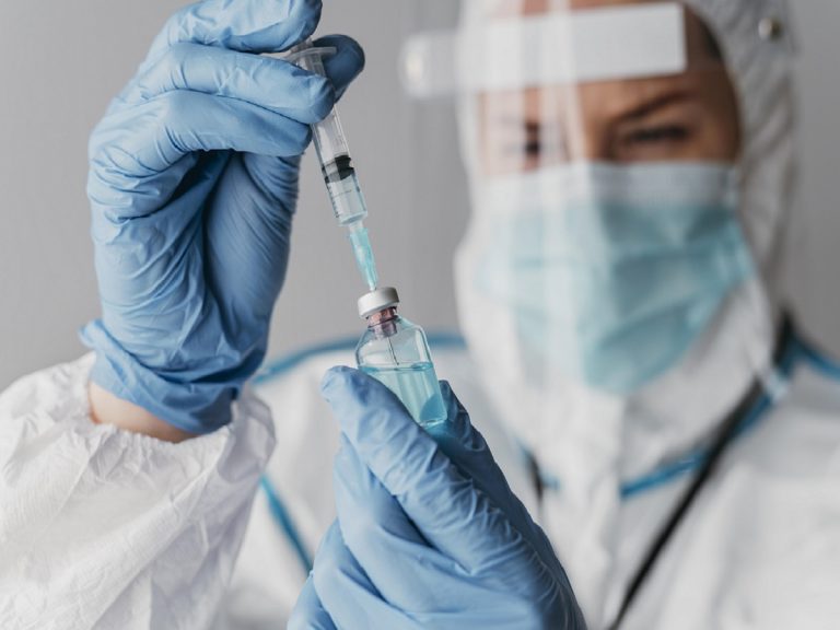 doctor-holding-preparing-vaccine-while-wearing-protective-equipment