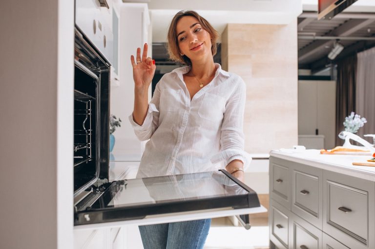 woman-baking-at-kitchen-and-looking-into-the-oven